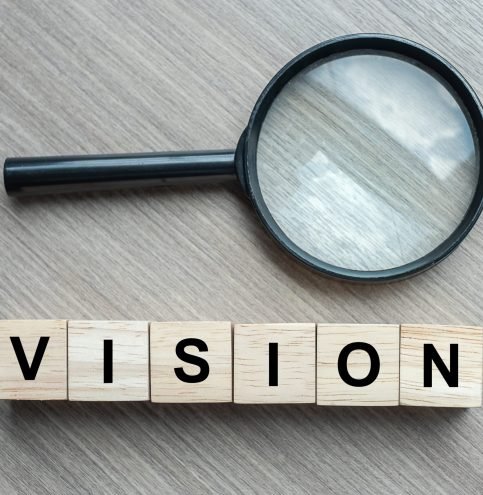 Vision text wooden cubes and magnifying glass on wood table background. SEO, Idea, Strategy, Analysis, goals and Values concept